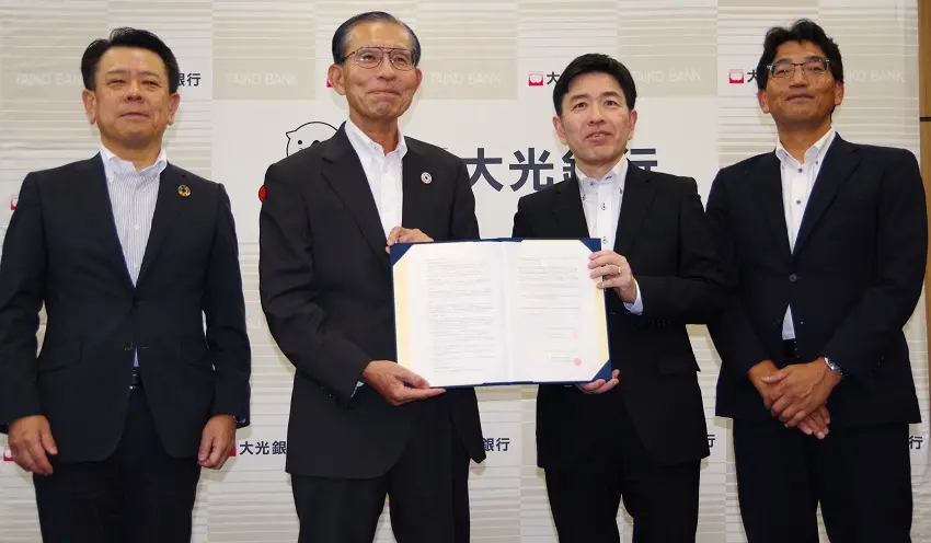 覚書を交わす石田頭取（左2人目）と商工中金の鍛冶取締役専務執行役員（左3人目、9月29日、大光銀行本部）